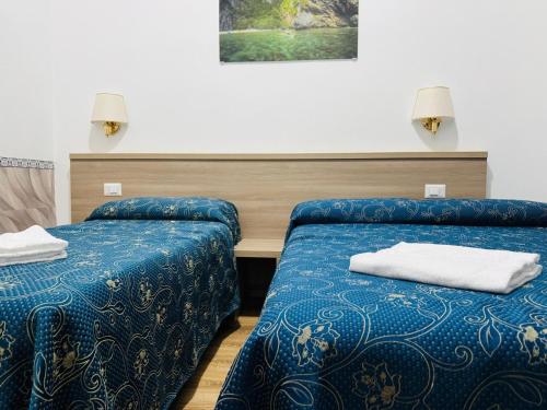 een kamer met twee bedden met een blauw dekbed bij Marziah Inn in Rome