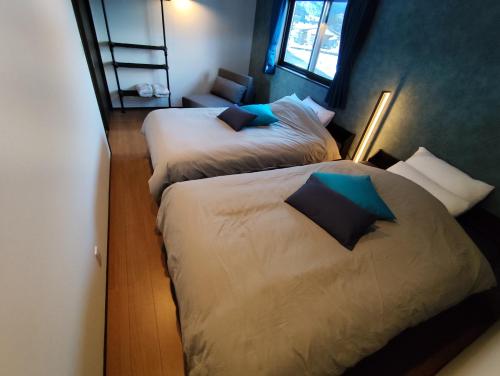 Nest SETSUGEN Villa في هاكوبا: سريرين في غرفة فندق مع سريرين sidx sidx sidx