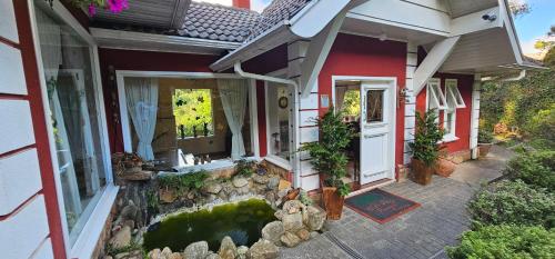 a house with a koi pond in front of it at Pousada Atalaia Premium in Campos do Jordão