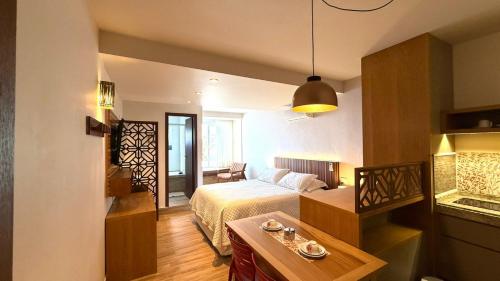 a hotel room with a bed and a table at Pousada Gamboa estações in Garopaba