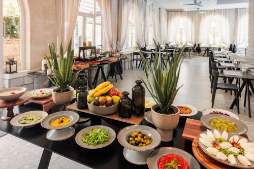 a buffet with bowls of fruit and vegetables on a table at Hotel Milna Osam - Adults Only in Milna
