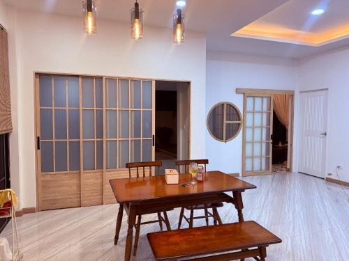 a living room with a wooden table and chairs at Home No 5 in Ratchaburi