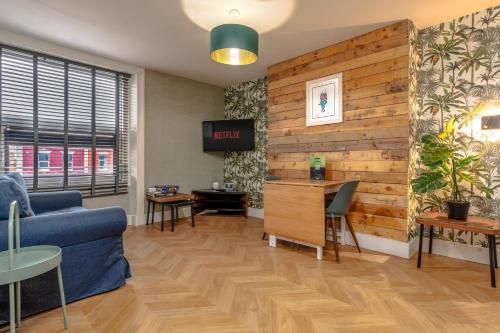 a living room with a blue couch and a wooden wall at City View Flat, Quiet Bedroom, Work Ready Desk in Bristol