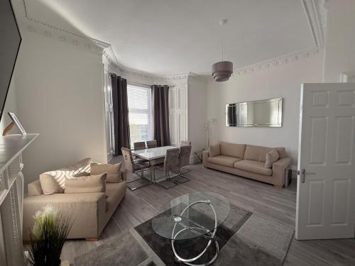 Casa Fresa - 31A High Street في Monifieth: غرفة معيشة مع أريكتين وطاولة