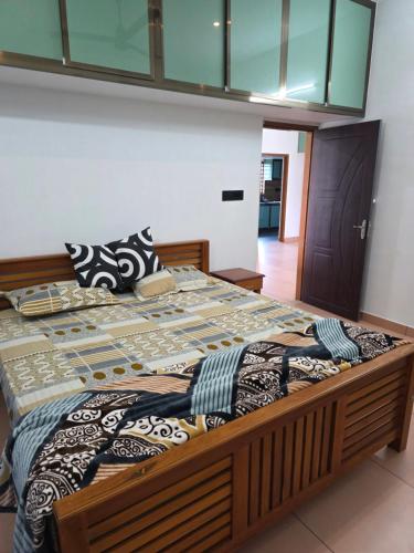 uma cama grande com uma estrutura de madeira num quarto em Metro Heights em Parunthumpara