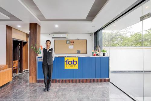 FabHotel Groom Room في نويدا: رجل في بدلة واقف في اللوبي