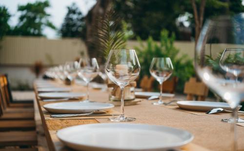 una larga mesa de madera con platos y copas de vino en Nong Lam Ecolodge, en Linh Xuân Thôn