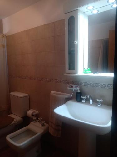 a bathroom with a sink and a toilet and a mirror at Casa La Escondida in Villa del Dique