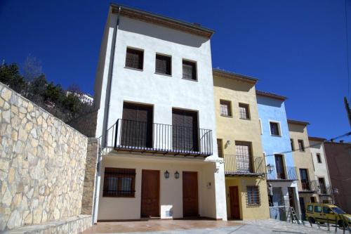 a white building with a balcony on top of it at Casa Puritat in Morella