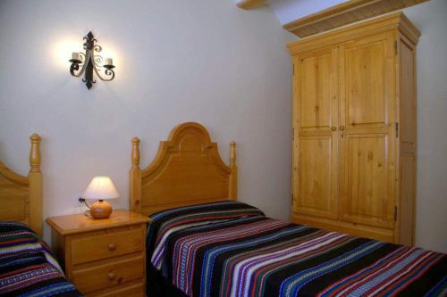 a bedroom with a bed and a dresser with a lamp at Casa Puritat in Morella