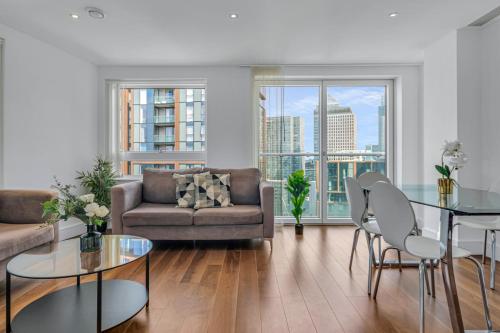a living room with a couch and a table and chairs at Talisman & Duckman Tower at Canary Wharf by MySquare in London