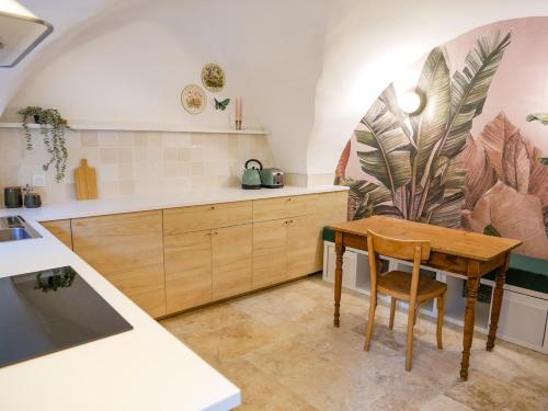 Gîte du Puy Drome Provençale Puygiron في Puygiron: مطبخ مع طاولة خشبية وغرفة طعام