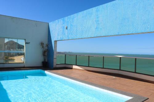 een zwembad in een gebouw met uitzicht op de oceaan bij Ocean Flat vista mar in Vila Velha