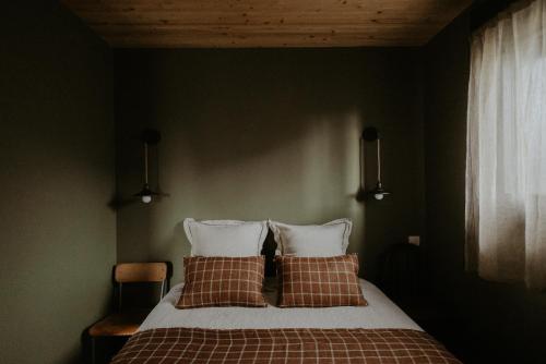 a bedroom with a bed with two pillows at Aux Choses Simples in Pradiers