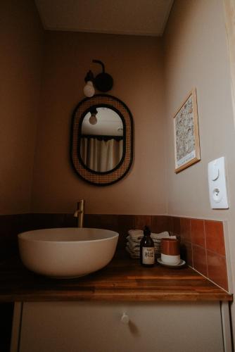 a bathroom with a sink and a mirror at Aux Choses Simples in Pradiers
