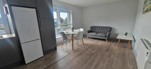 a kitchen with a table and a chair and a refrigerator at Refurbed 4BDR Home on Dock Road Near City Centre in Limerick