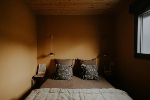 una camera da letto con un letto grande con due cuscini di Aux Choses Simples 