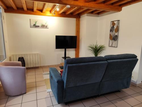 a living room with a blue couch and a television at Appartement 3 Chambres Bollezeele in Bollezeele