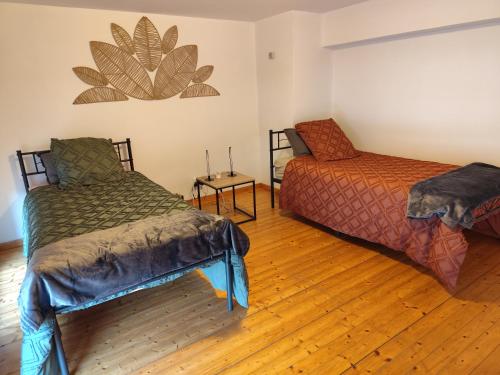 a room with two beds and a chair in it at Appartement 3 Chambres Bollezeele in Bollezeele