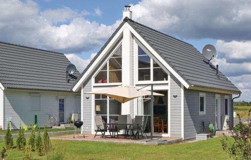 a white house with a table and an umbrella at Lykkebo in Wandlitz