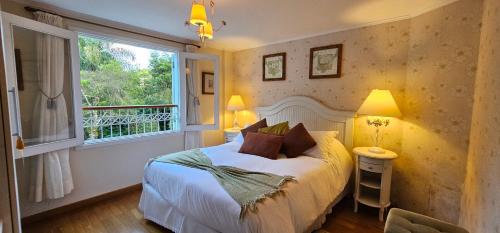 a bedroom with a bed and a window at Pousada Atalaia Premium in Campos do Jordão