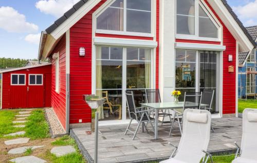 una casa rossa con patio arredato con tavolo e sedie di Onkel Toms Hütte a Wandlitz
