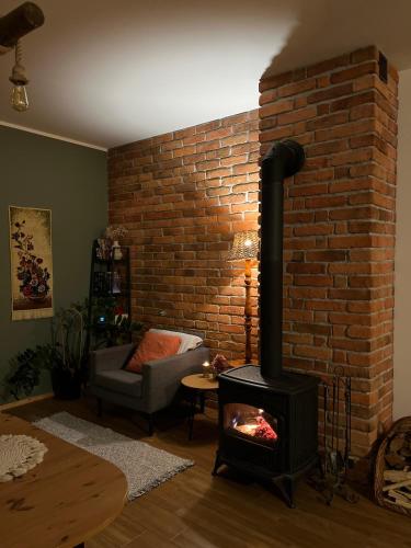 a living room with a brick wall and a wood stove at Przystanek Gałkowo in Gałkowo