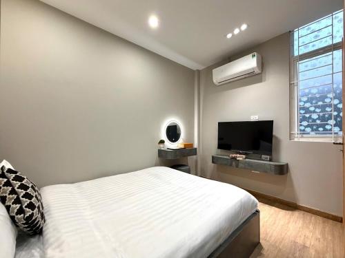 um quarto com uma cama e uma TV de tela plana em The Indochina Homestay and Travel by Nguyen em Hanói