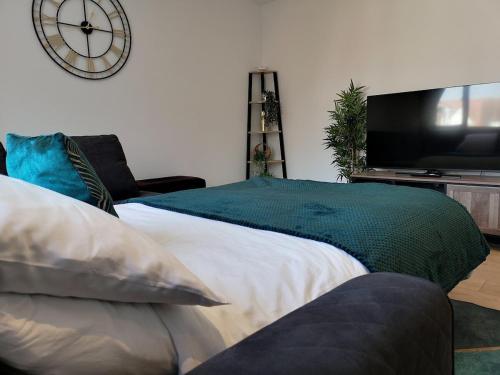 a bedroom with a bed and a clock on the wall at Fresh Spring Getaway-Christchurch Town Centre in Christchurch