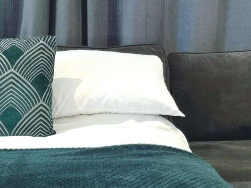 a bed with two pillows on top of it at Fresh Spring Getaway-Christchurch Town Centre in Christchurch