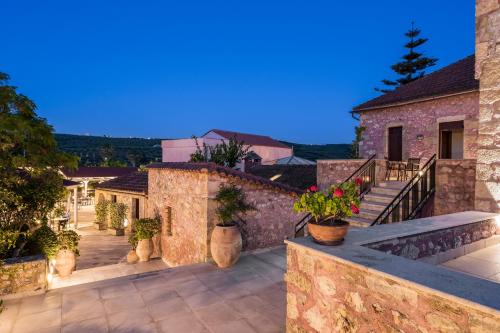 a house with a balcony with potted plants on it at Spilia Village Hotel & Villas in Spiliá