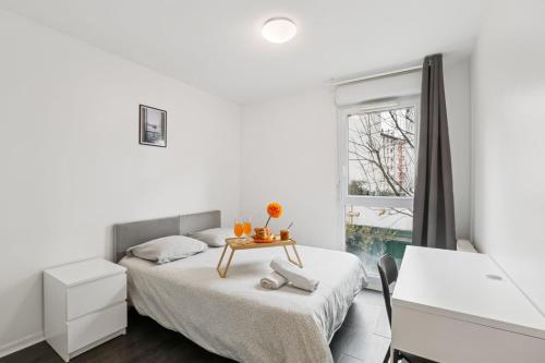 Un dormitorio blanco con una cama y una mesa. en Superbe 90M2, chic & cosy avec Parking privé et Terrasse - 10pers, en Villeurbanne