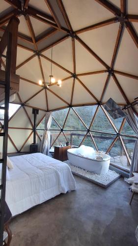 a room with a bed and a tub in a tent at Zaca Domos l Ouro Preto - MG in Mariana