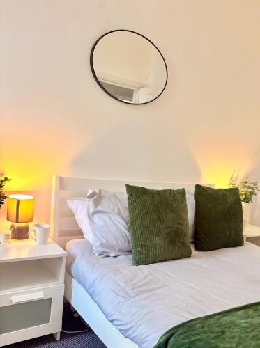 Schlafzimmer mit einem Bett und einem Spiegel an der Wand in der Unterkunft Modern & Spacious 2-bed flat - Central Cardiff - Fast Wifi - Long & Short Stay in Cardiff