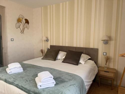 een slaapkamer met een bed met handdoeken erop bij L'Evasion Troyenne T21 in Troyes