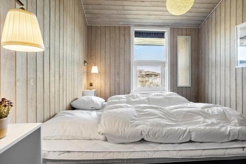 een groot wit bed in een slaapkamer met een raam bij 941-Thisted-Klitstien-37 in Torsted