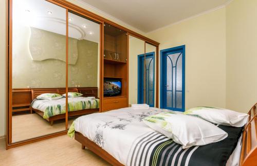 a bedroom with two beds and a large mirror at Three bedroom, 8 Lyuteranska str, Centre of Kiev in Kyiv