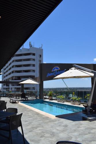 Una piscina con sombrillas al lado de un edificio. en Howard Johnson Ciudad del Este, en Ciudad del Este