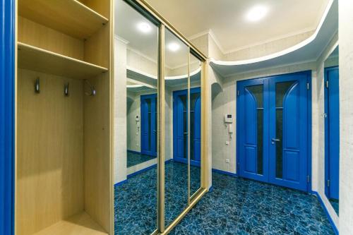 a hallway with blue doors and mirrors at Three bedroom, 8 Lyuteranska str, Centre of Kiev in Kyiv