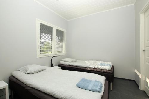 two twin beds in a room with two windows at Amiraali in Jämsä