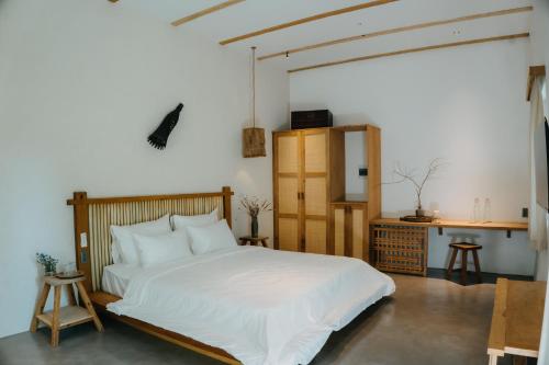 een slaapkamer met een groot wit bed en een bureau bij Nong Lam Ecolodge in Linh Xuân Thôn