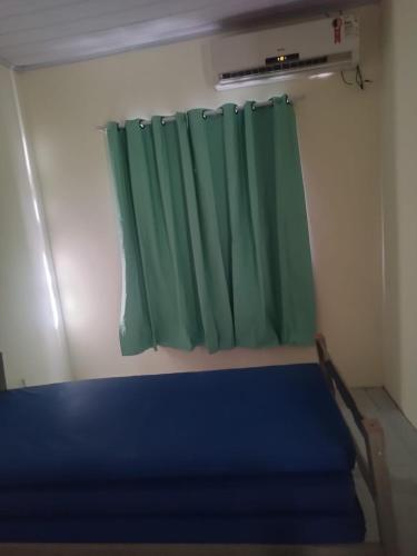 una camera con finestra con tenda verde di Casa Morato a Mata de Sao Joao