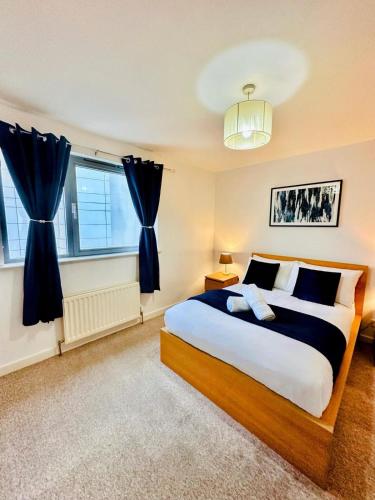a bedroom with a large bed and two windows at Scotapartments in Edinburgh