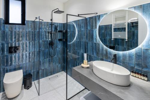 Un baño con lavabo, inodoro y espejo. en Nouvelle Hotel, en Oni