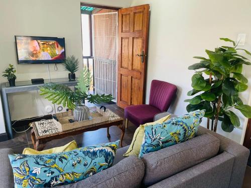 5 OYSTER COTTAGE في ديربان: غرفة معيشة بها أريكة وطاولة