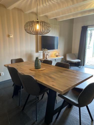 a dining room with a wooden table and chairs at Valley view cottage vlakbij Valkenburg in Voerendaal