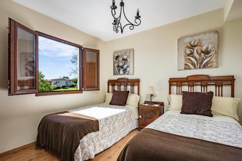 Un dormitorio con dos camas y una ventana. en La Piñera, pola de Siero, en Siero