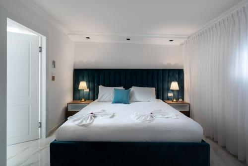 a bedroom with a large white bed with two lamps at וילה מילגרוס - וילה עם בריכה פרטית מחוממת ומקורה - נוף לים in ‘Ein Ya‘aqov