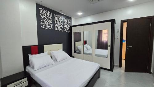 a bedroom with a large bed with white sheets at T2 Cosy & Central Akid Lotfi in Oran