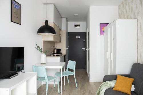 a small apartment with a kitchen and a table and chairs at ADLER Room Suite in Łódź